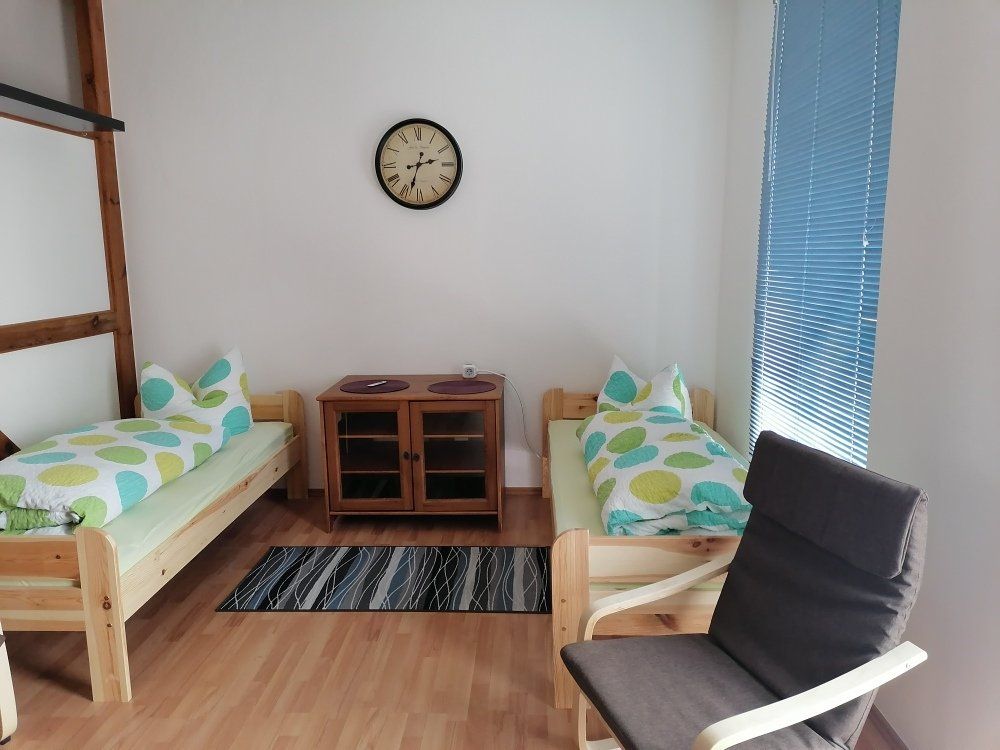 Ein Schlafzimmer mit zwei Betten und einer Uhr an der Wand