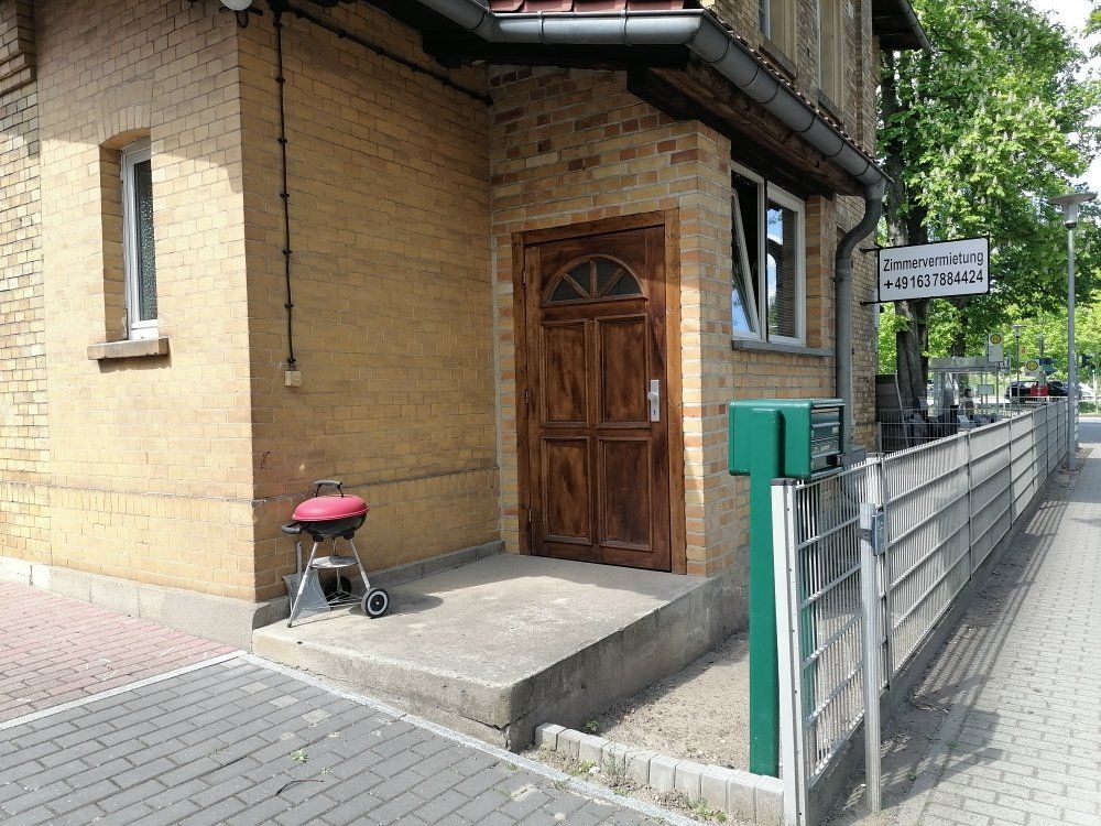 Auf dem Bürgersteig vor einem Backsteingebäude steht ein Grill.