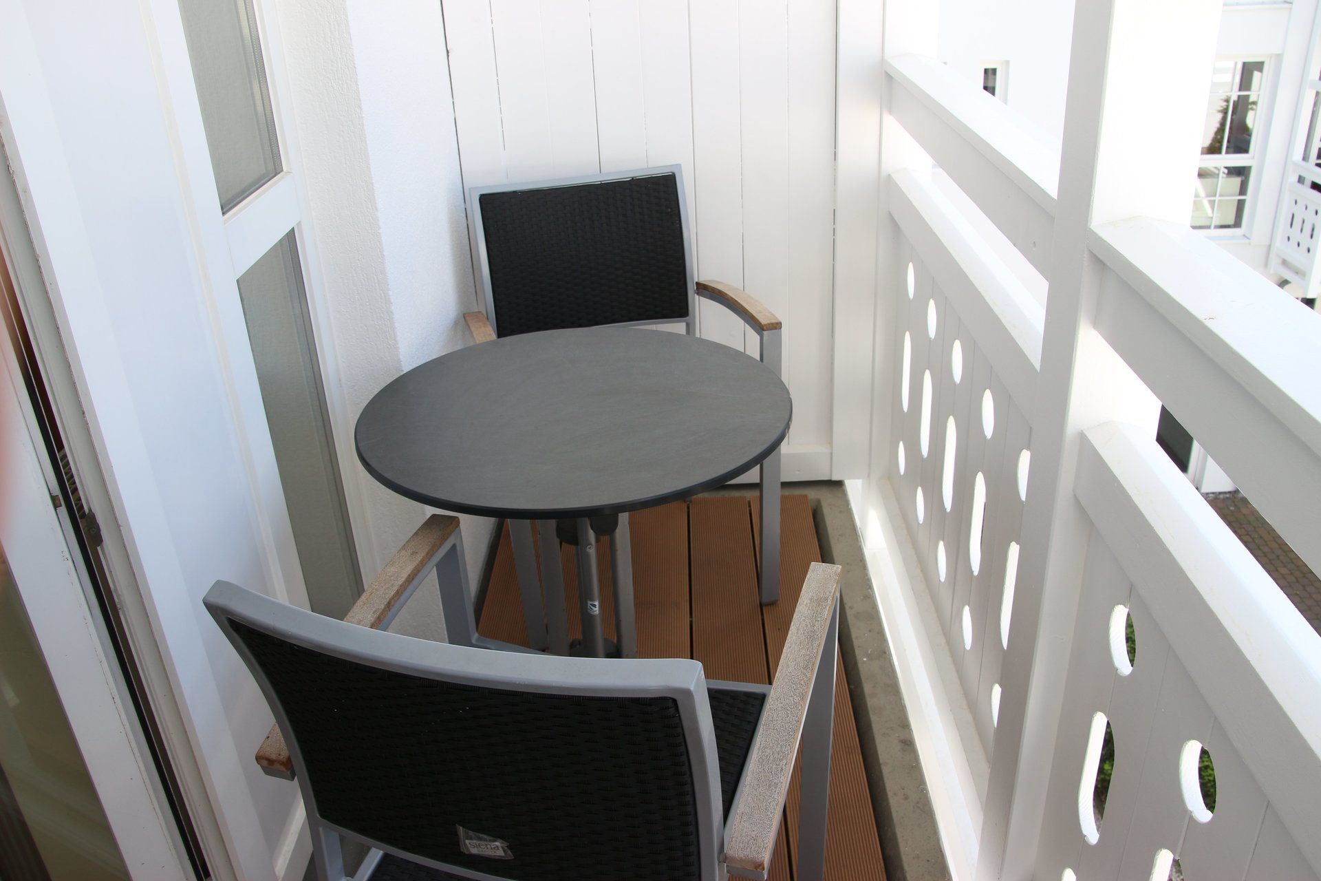 Ein kleiner Balkon mit Tisch und Stühlen