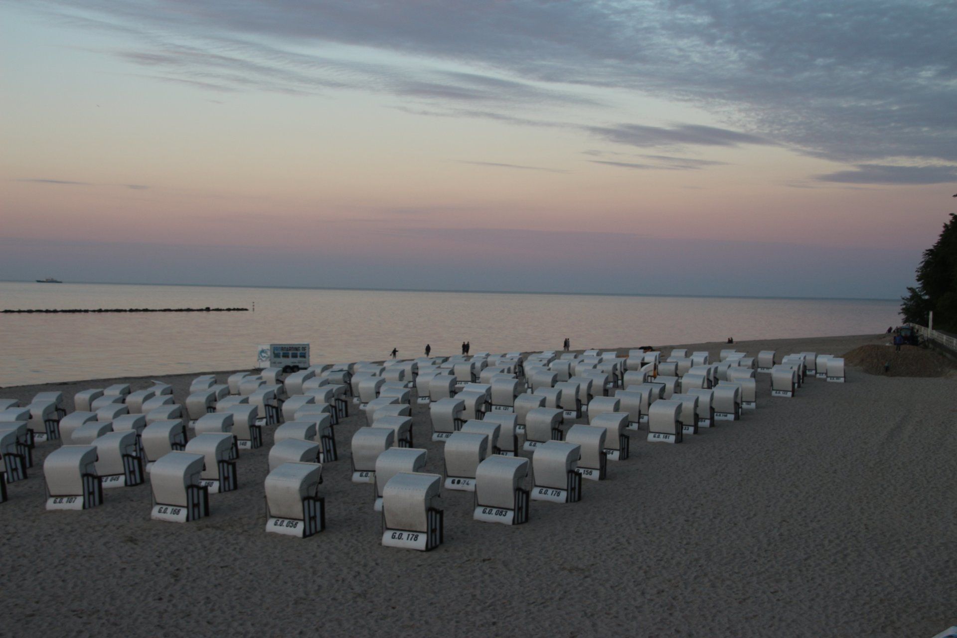 Eine Reihe von Liegestühlen steht an einem Sandstrand