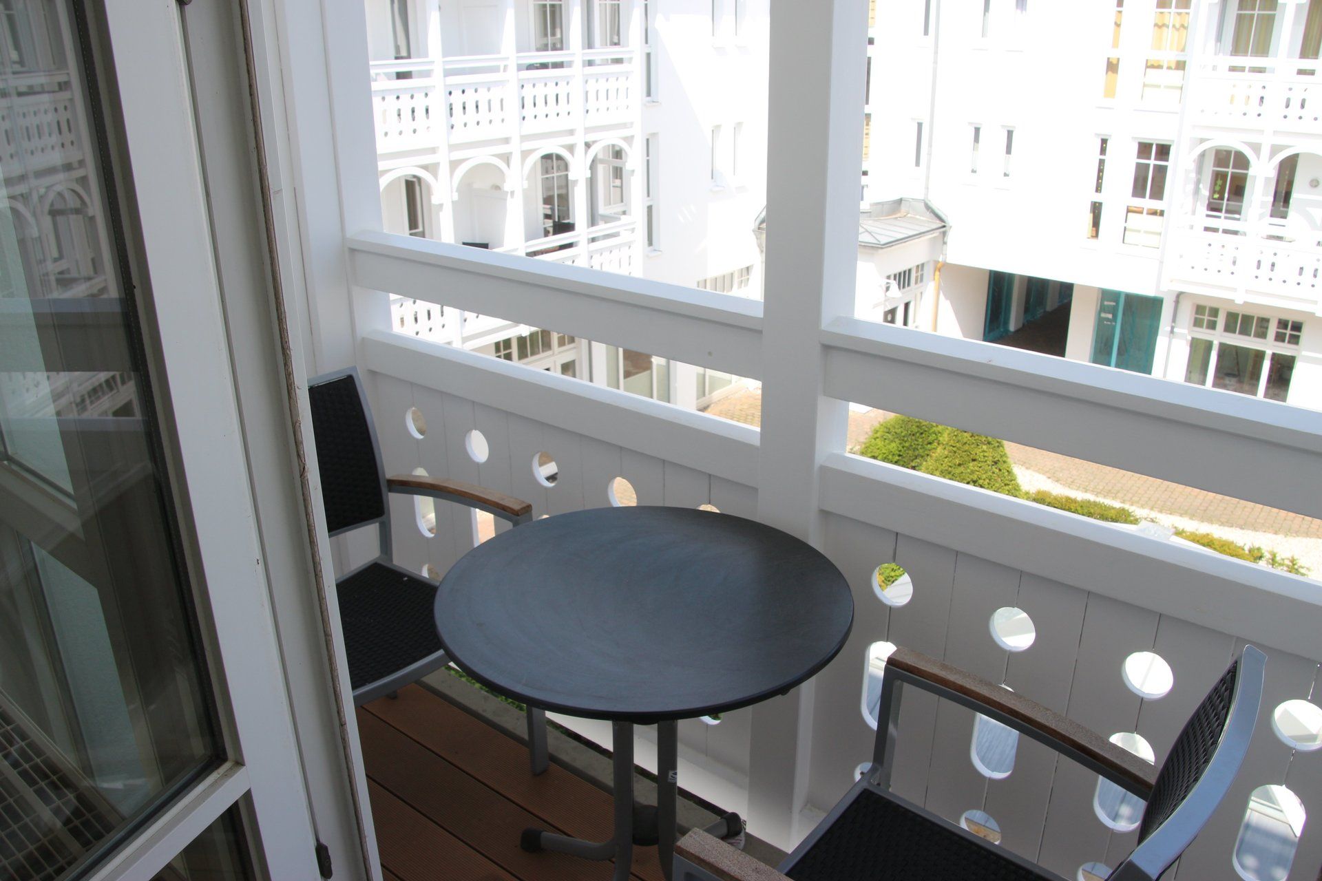 Ein Balkon mit Tisch und Stühlen und Blick auf ein Gebäude