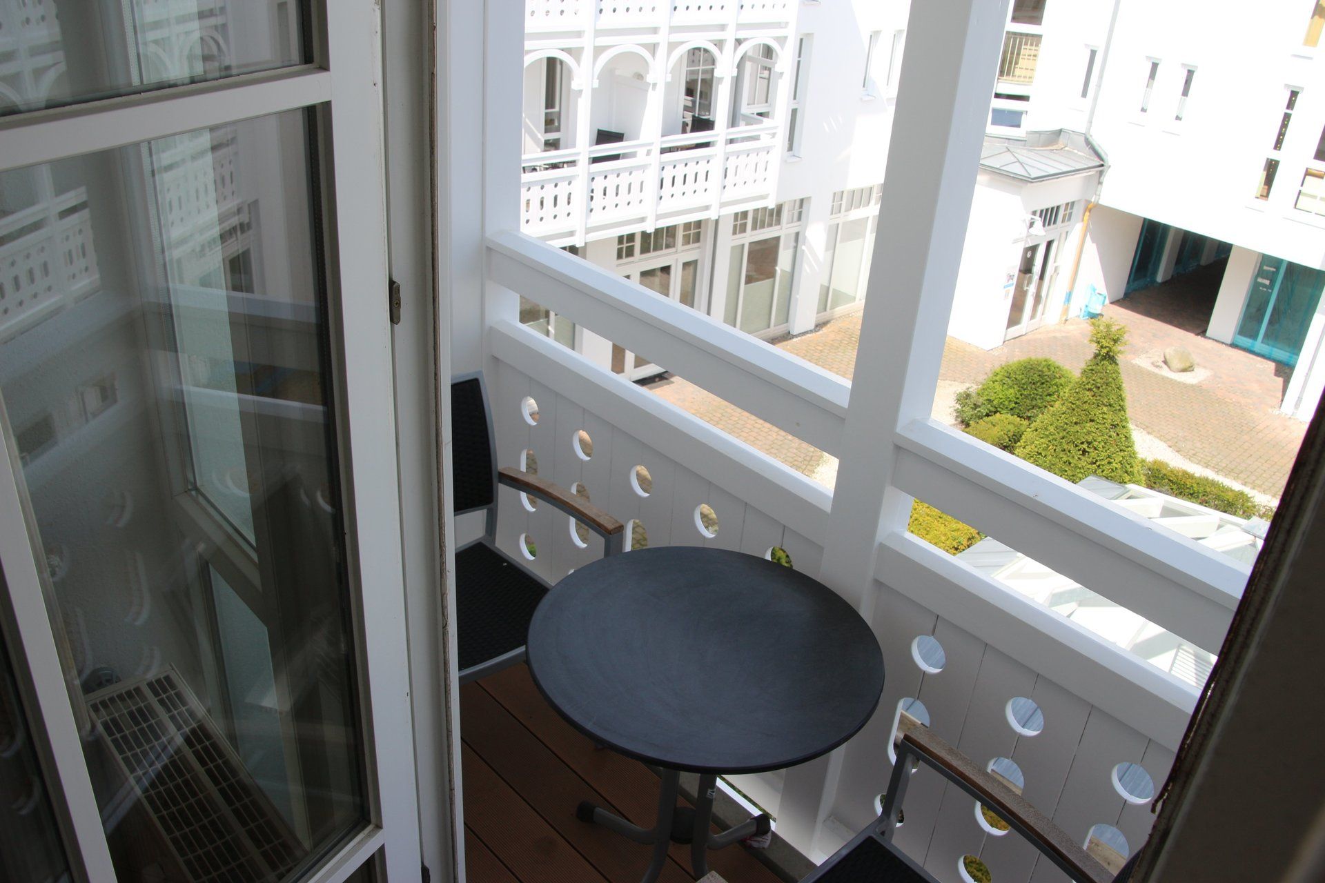 Ein Balkon mit Tisch und Stühlen und Blick auf ein Gebäude