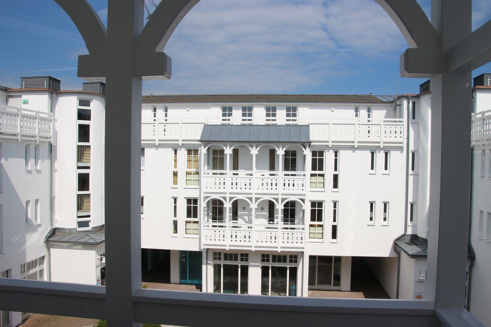 Blick von einem Balkon auf ein weißes Gebäude