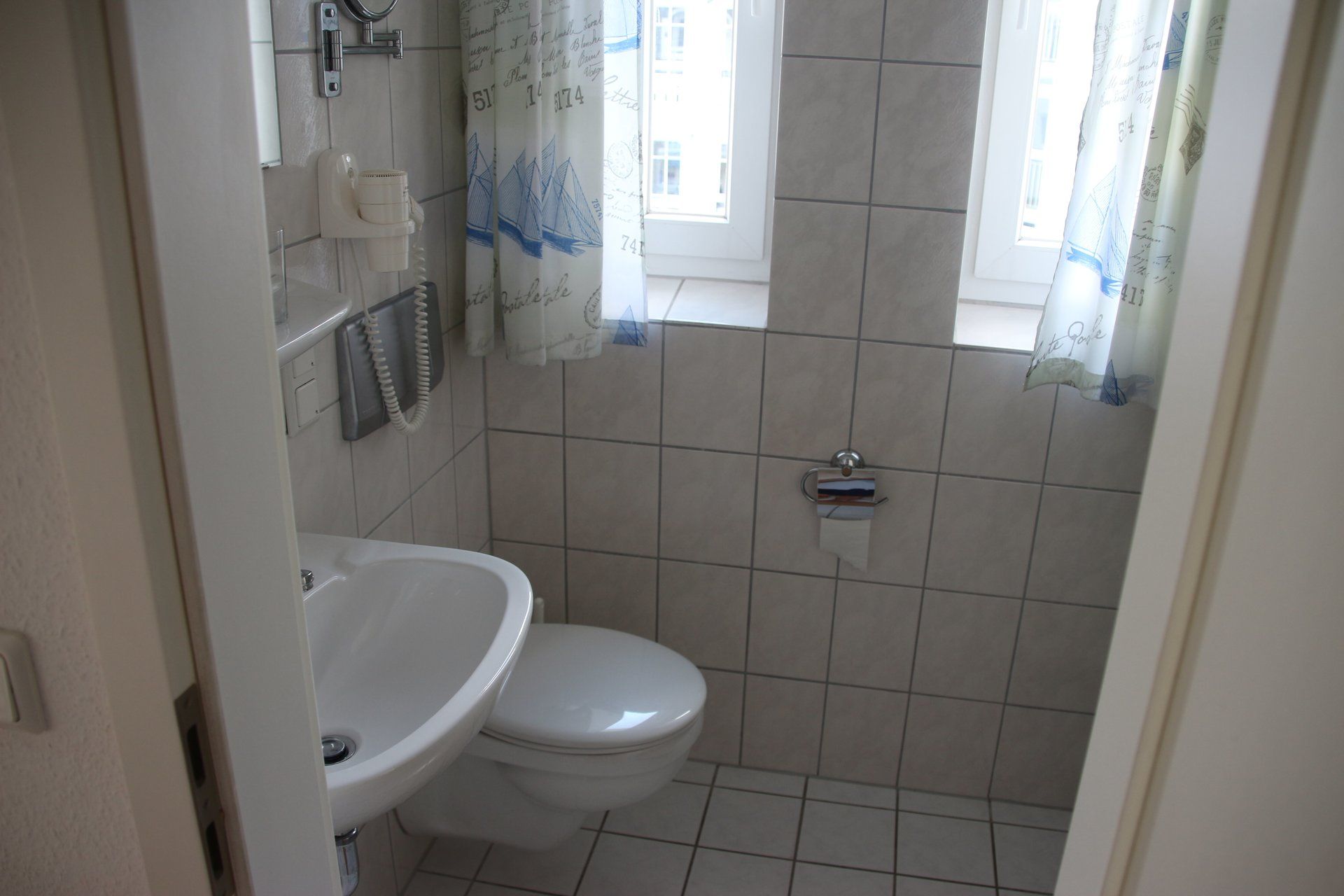 Ein Badezimmer mit Toilette, Waschbecken und Fenster