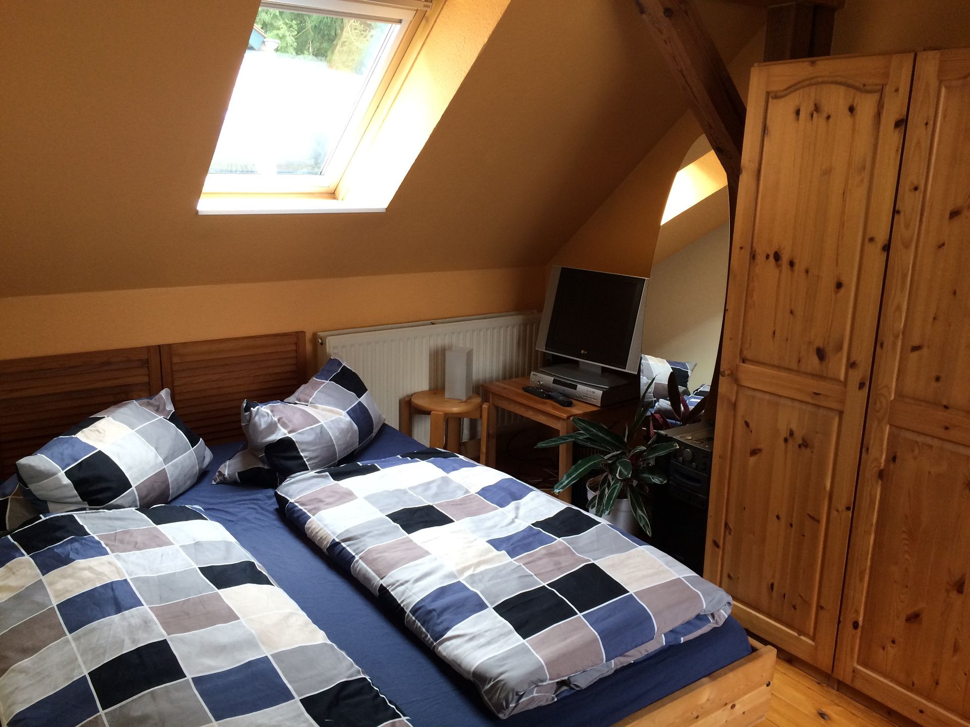 Ein Schlafzimmer mit zwei Betten, einem Schreibtisch und einem Fenster