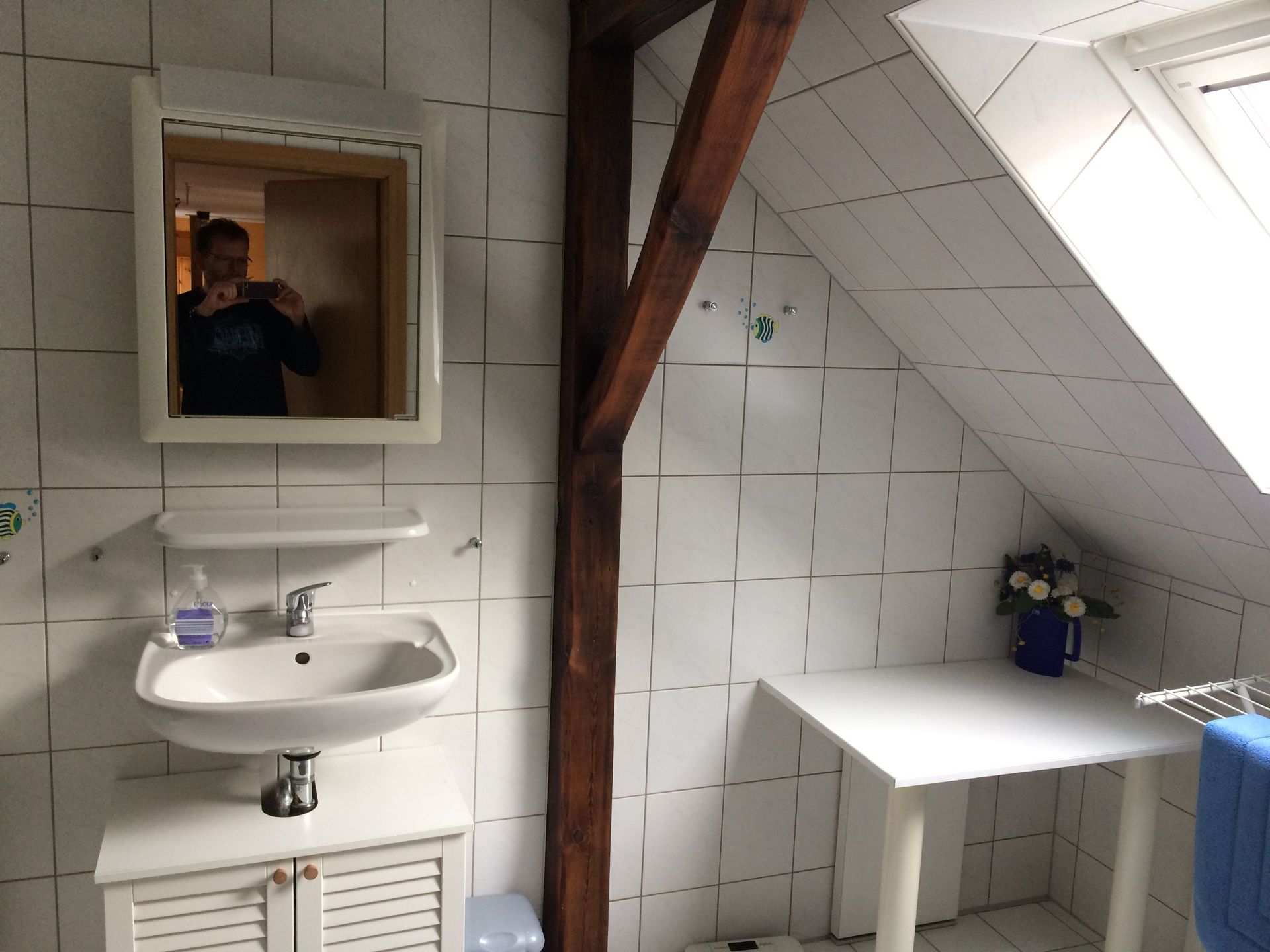 Ein Badezimmer mit Waschbecken, Spiegel und Tisch