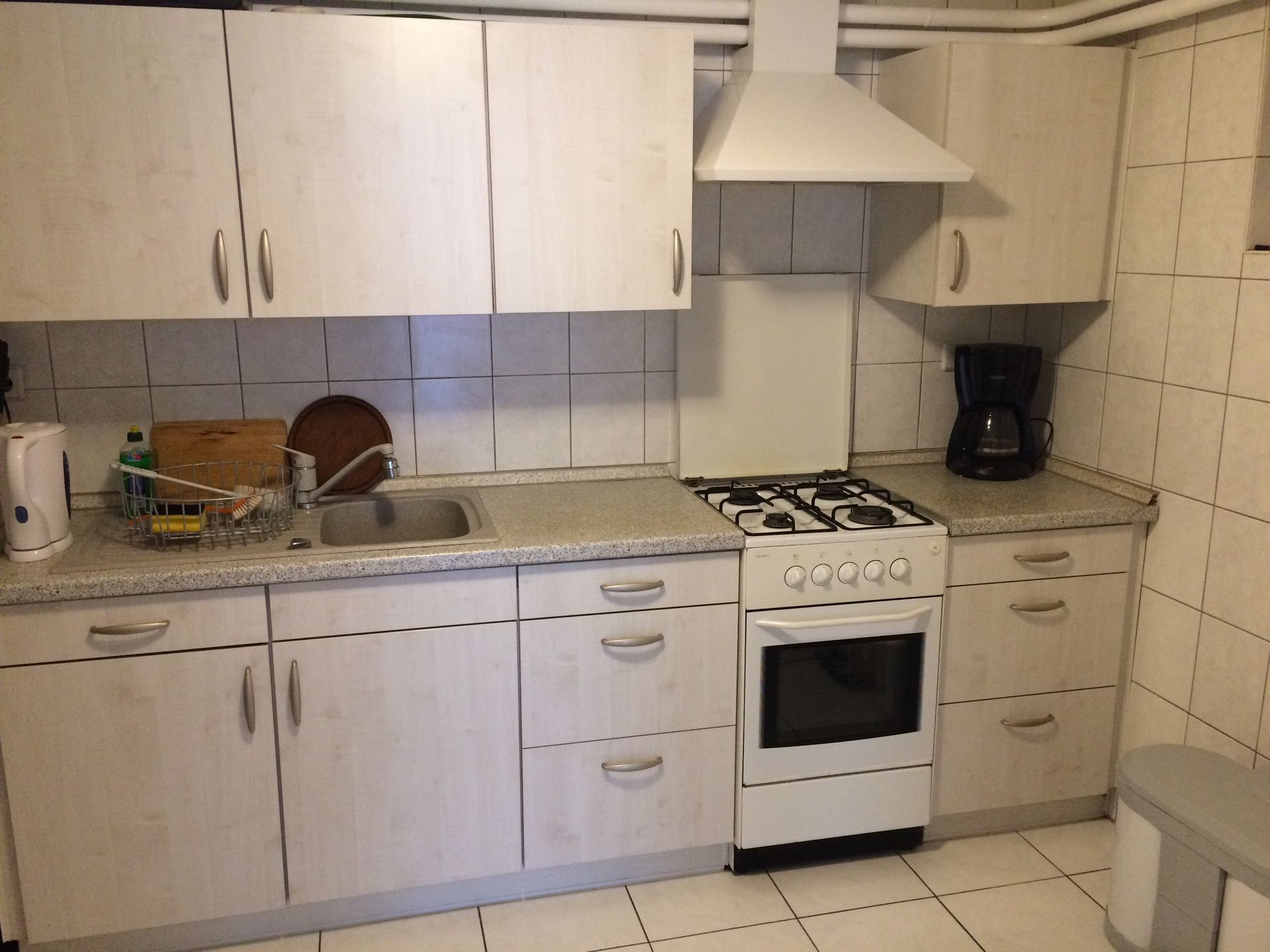 Eine Küche mit weißen Schränken und einem Herd mit Backofen