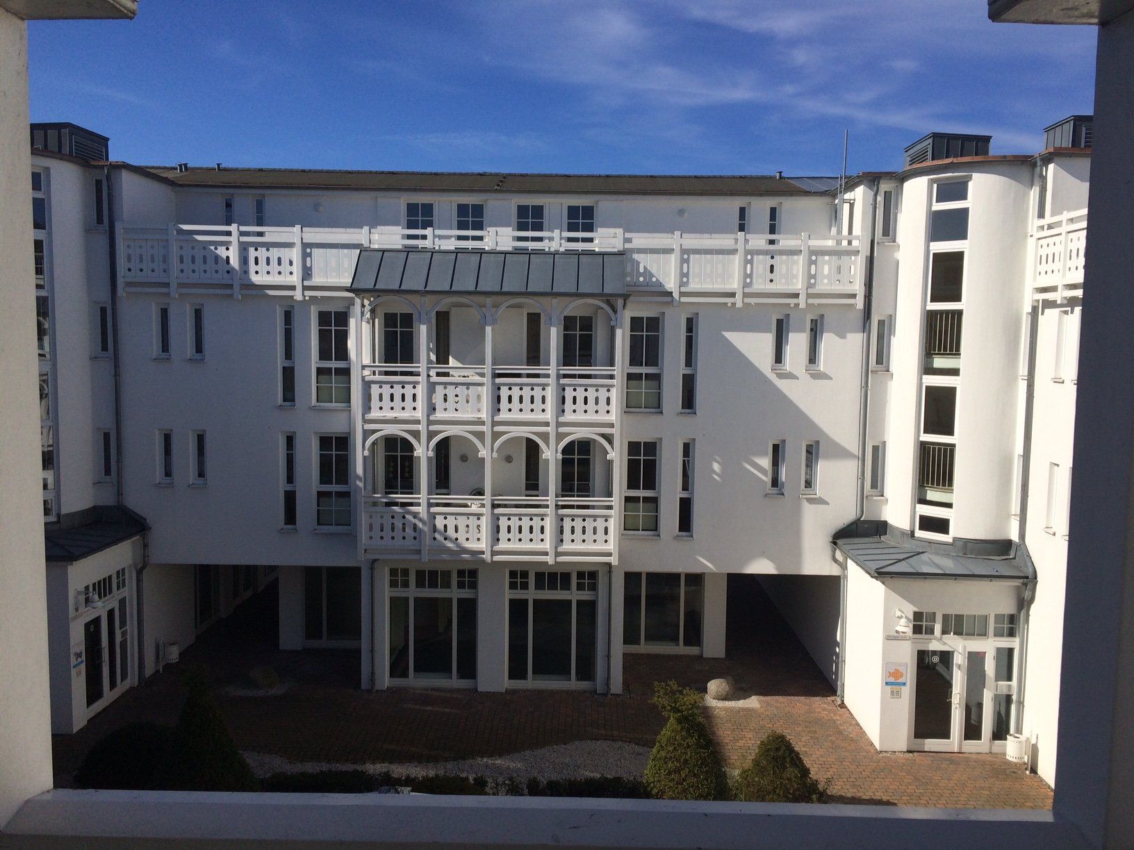 Ein großes weißes Gebäude mit vielen Fenstern und Balkonen