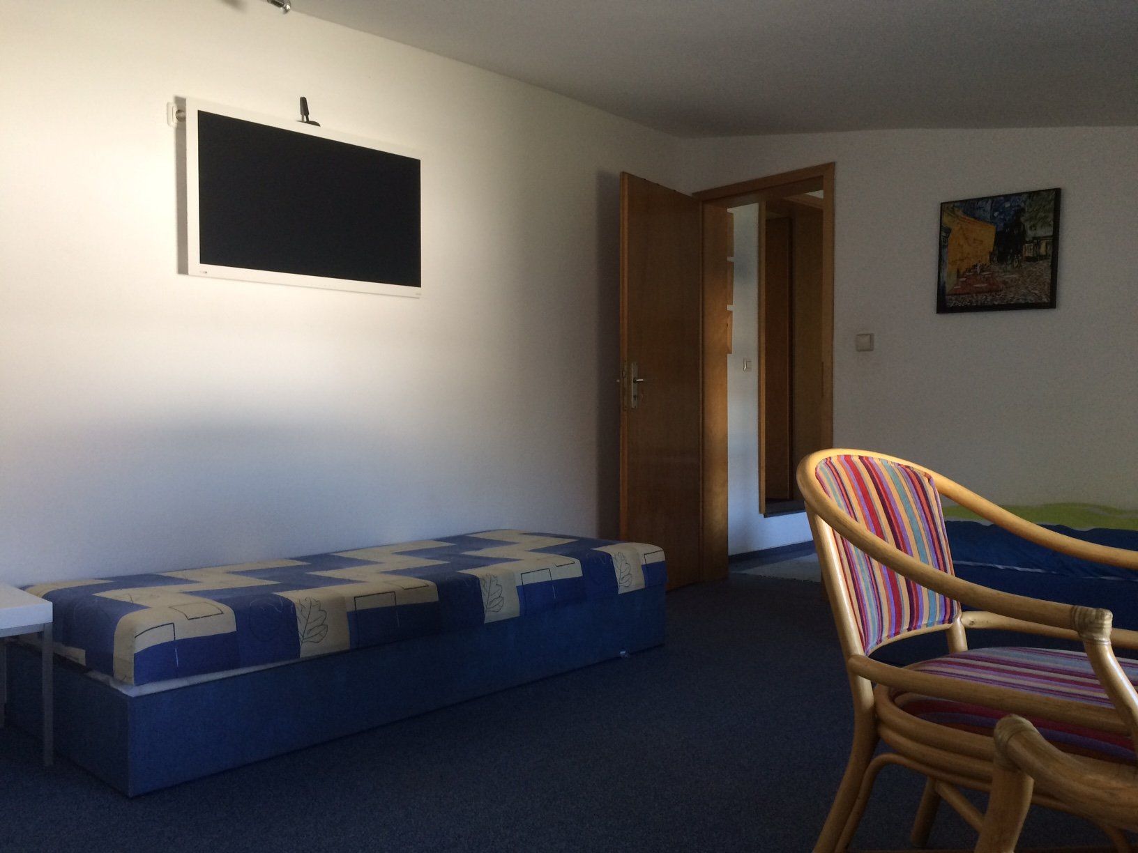 Ein Wohnzimmer mit einer blauen Bank und einem Stuhl