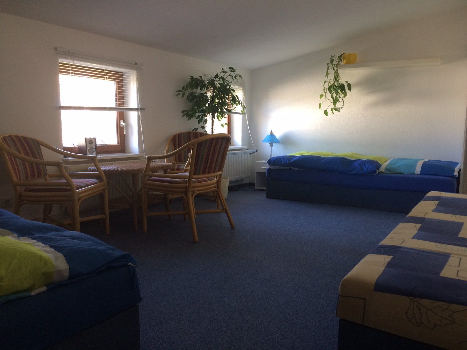 Ein Wohnzimmer mit einer blauen Couch und Stühlen