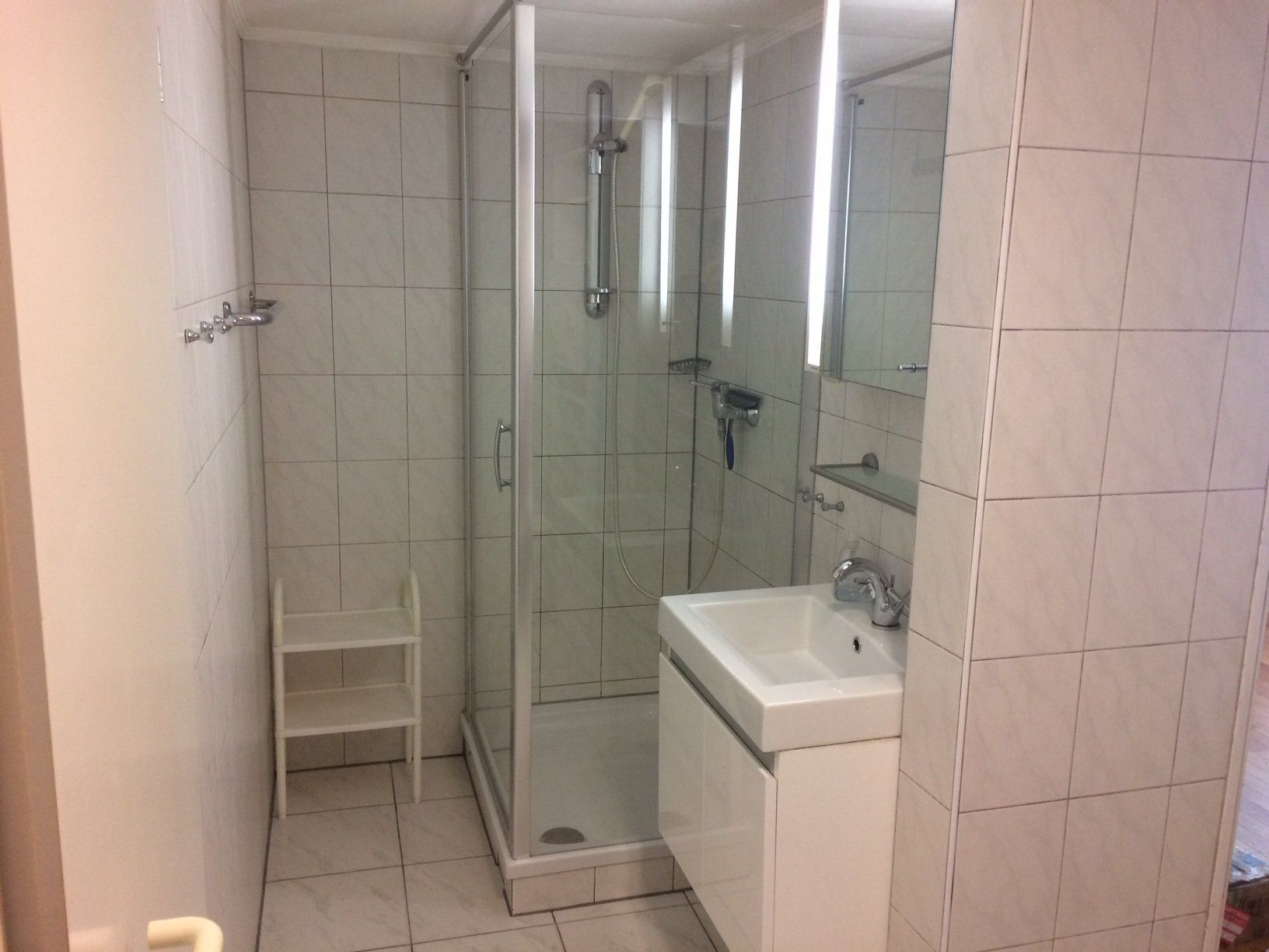 Ein Badezimmer mit Waschbecken und Duschkabine