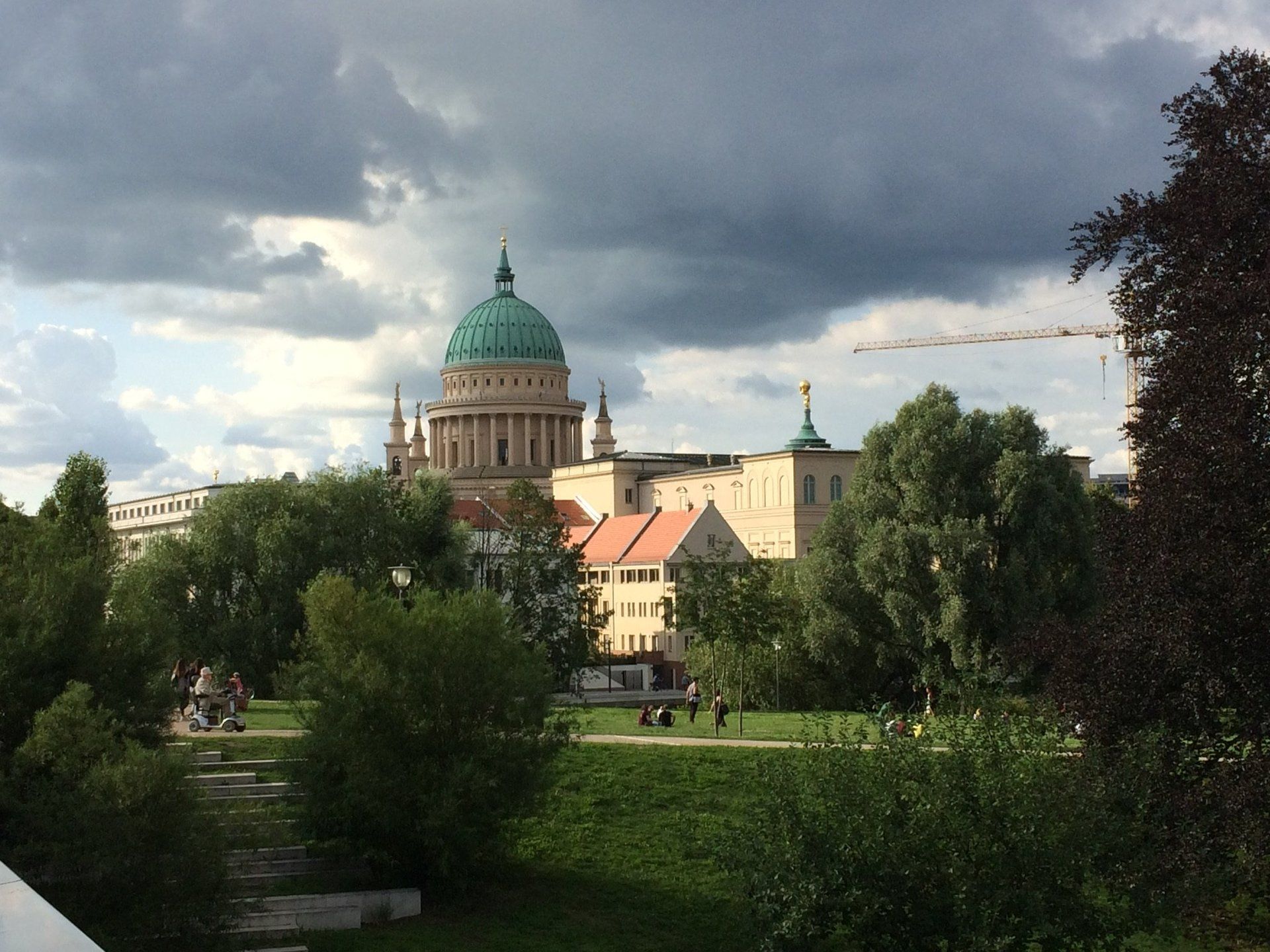 Ein großes Gebäude mit einer grünen Kuppel ist von Bäumen umgeben