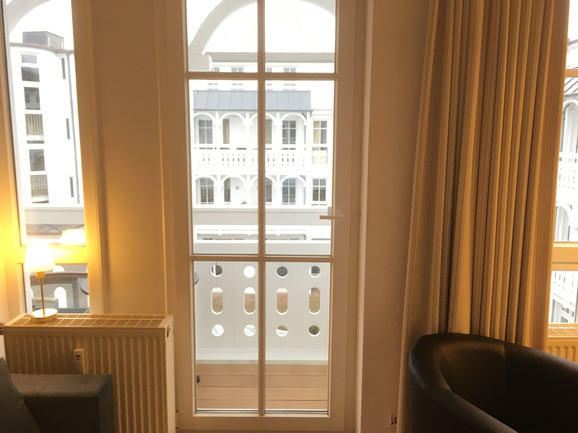 Ein Wohnzimmer mit großem Fenster und Balkon.