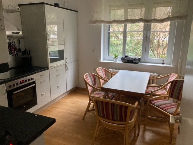 Eine Küche mit Tisch und Stühlen und einem Fenster