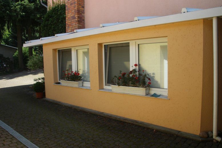 Ein Haus mit vielen Fenstern und Blumen in den Fenstern