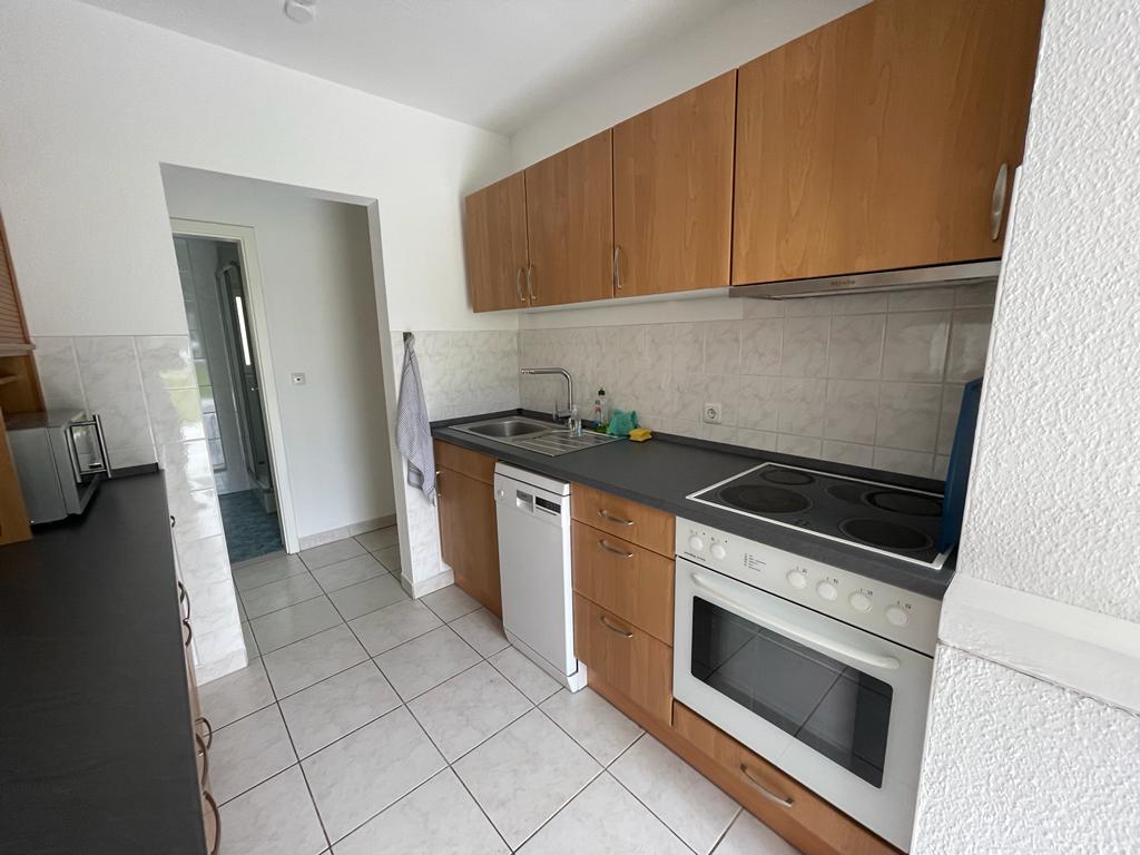 Eine Küche mit Holzschränken, Herd, Geschirrspüler und Mikrowelle.