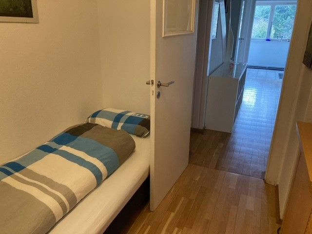 Ein Schlafzimmer mit Einzelbett und ein Flur