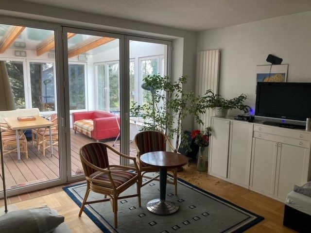 Ein Wohnzimmer mit Tisch und Stühlen und einem Fernseher