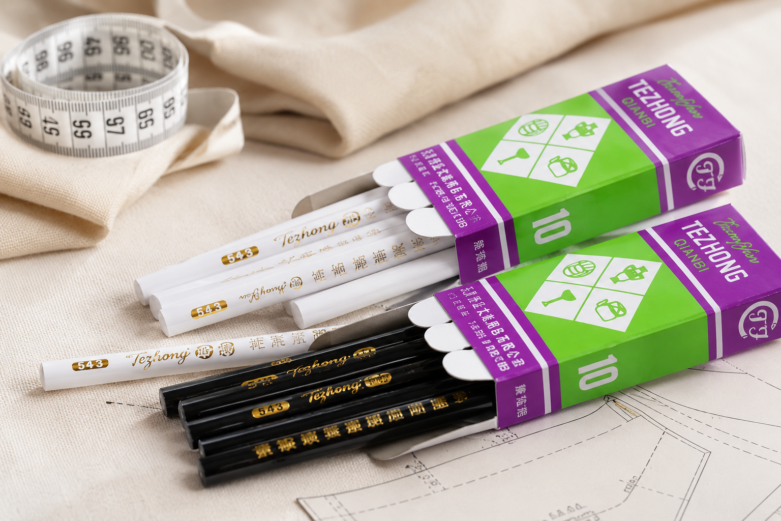 Lápiz de Sastreria White and black wooden pencils in purple and green packaging on a beige fabric background