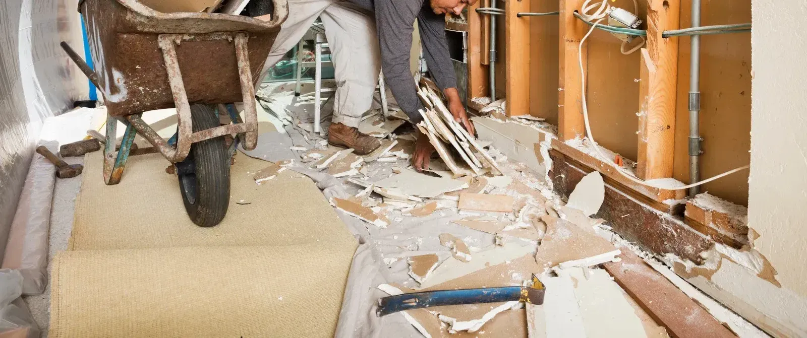 A man is sitting on a wheelbarrow in a room.
