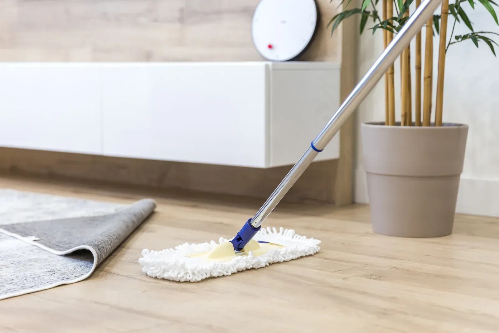 A group of people are cleaning an office with a vacuum cleaner.