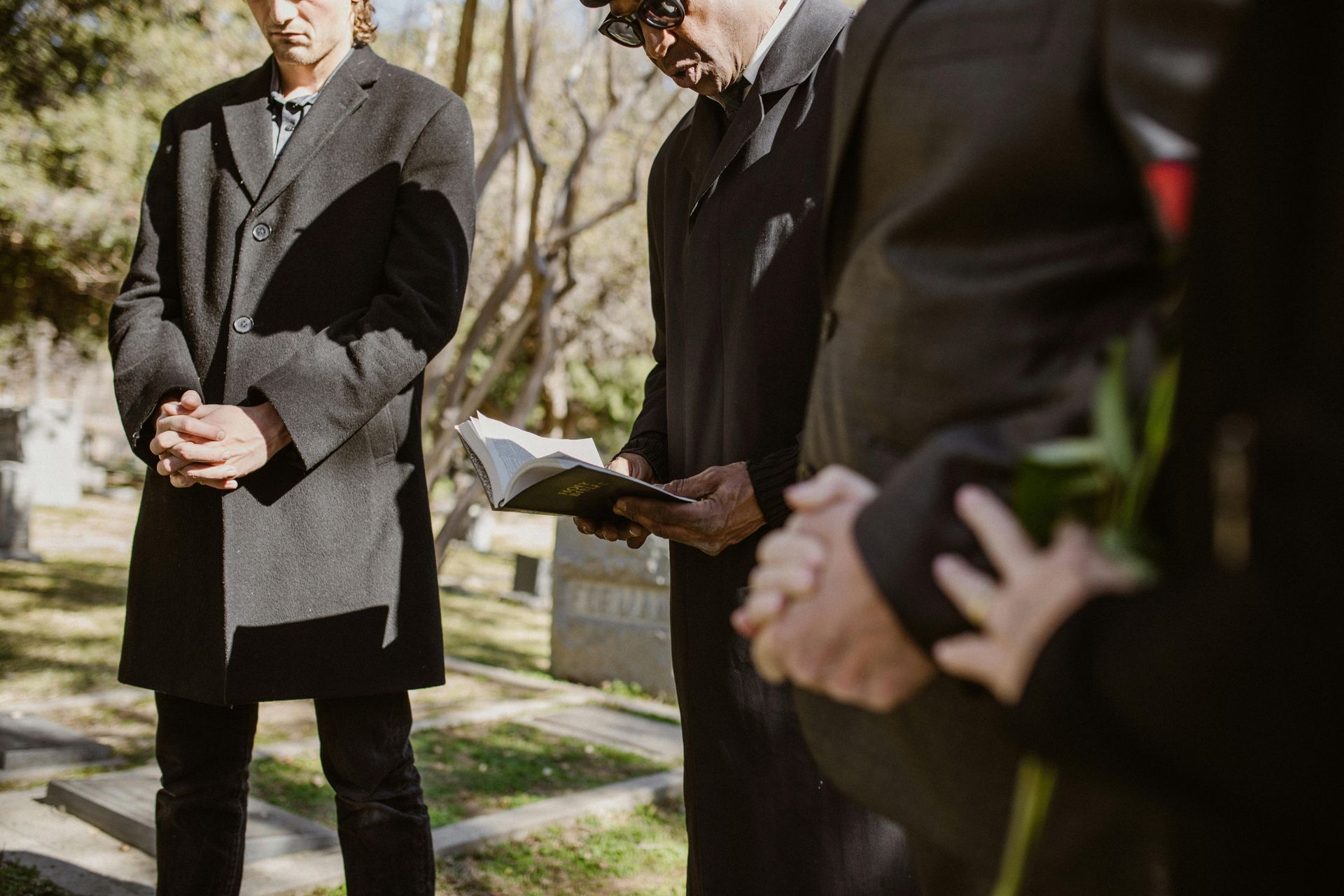A woman is putting her hand on an American flag at a funeral.