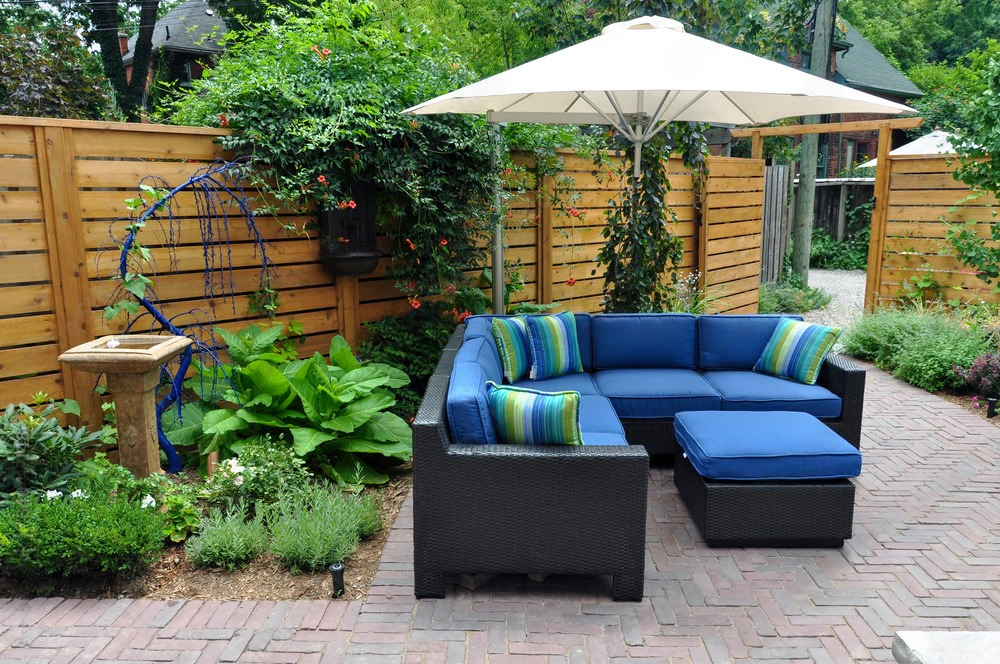 a patio with a sectional couch and an umbrella