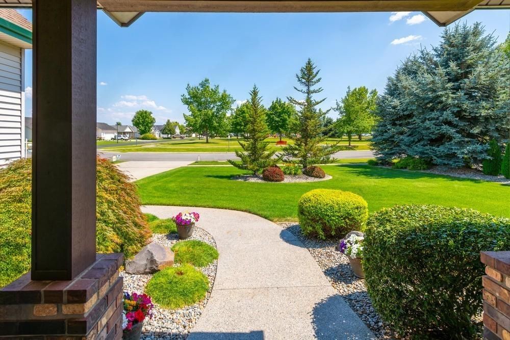 a view of a lush green yard from the porch of a house .