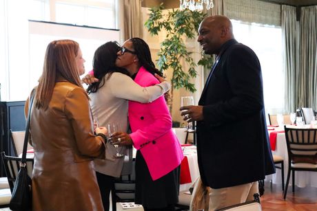 A group of people are hugging each other in a room.