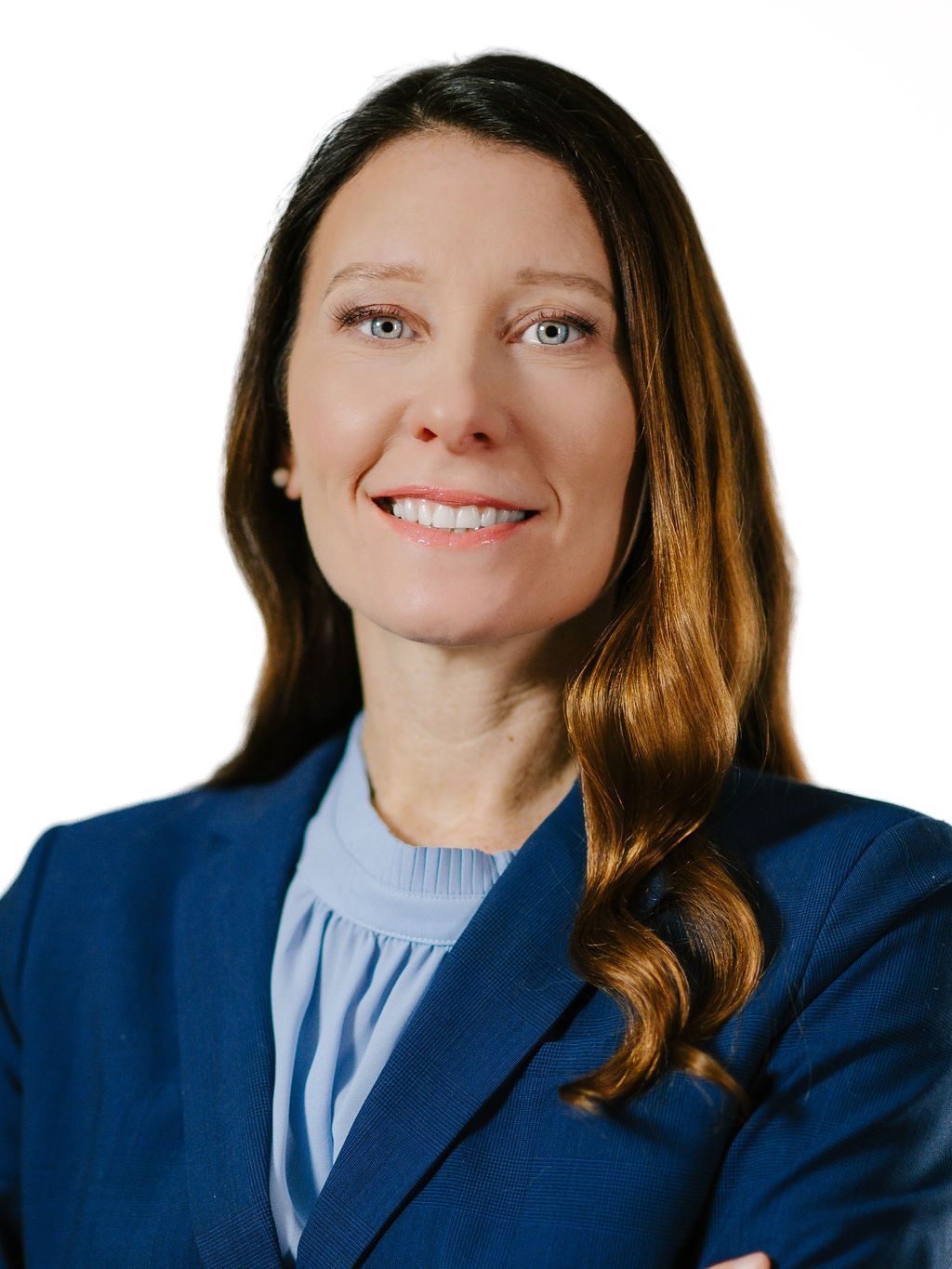 A woman with red hair is wearing a black jacket and a blue shirt.