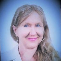 A woman with long blonde hair is smiling for the camera.