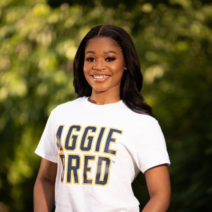 A woman wearing a white t-shirt that says aggie red