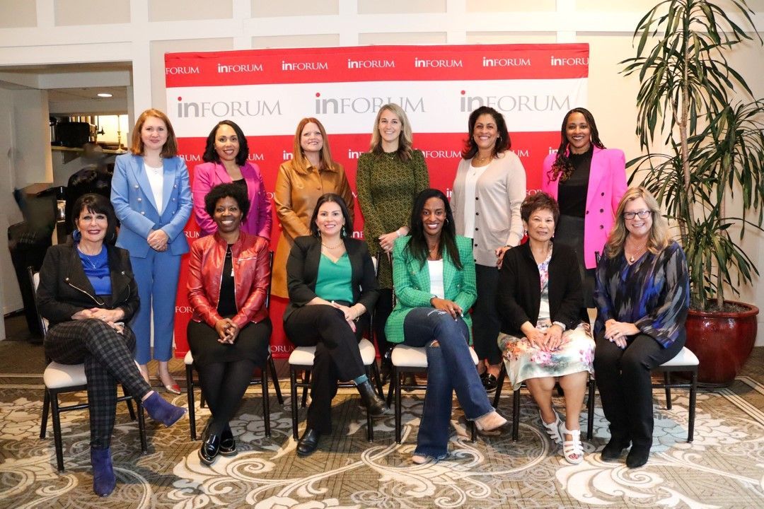 A group of women are sitting in chairs posing for a picture.