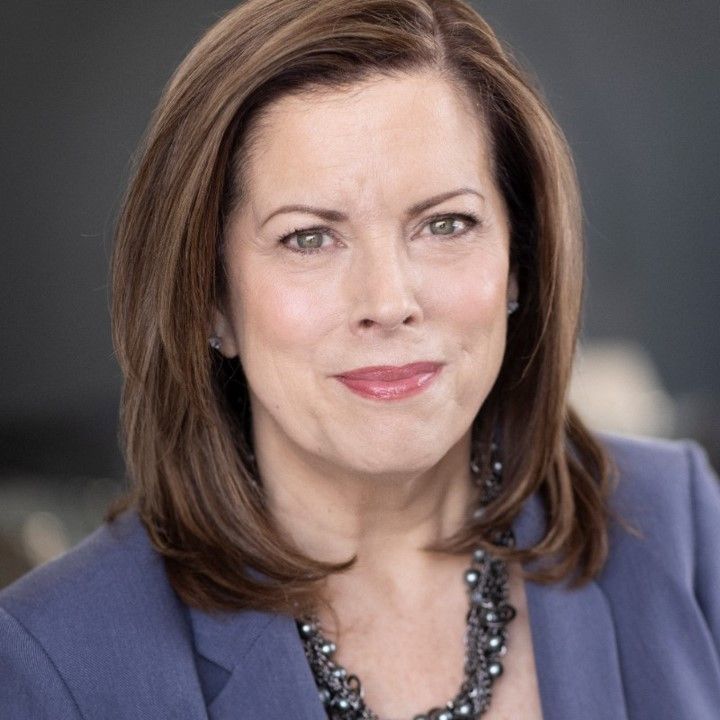 A woman in a black shirt is smiling for the camera.