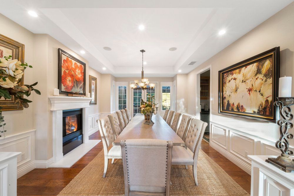 a dining room with a long table and chairs and a fireplace