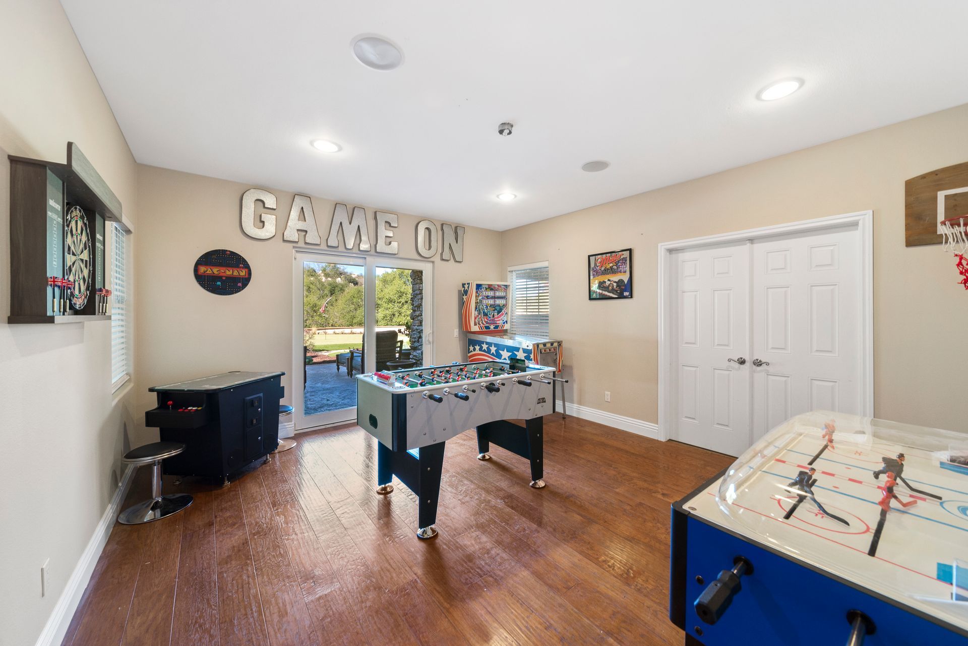 A game room with a foosball table and a basketball hoop.