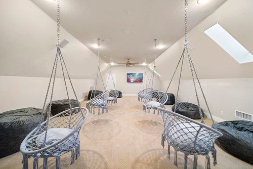 a room with a lot of chairs hanging from the ceiling