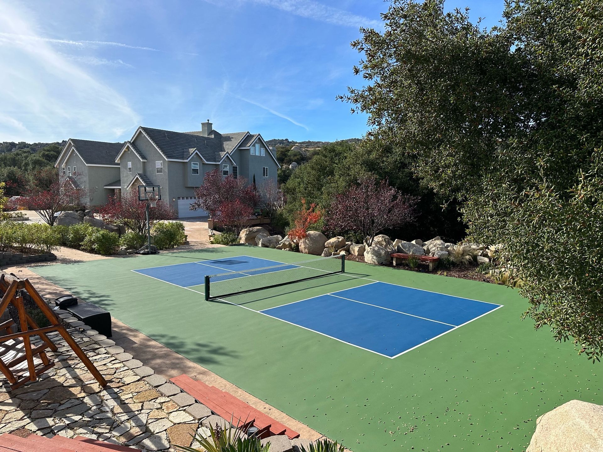 a pickleball court with a large house in the background