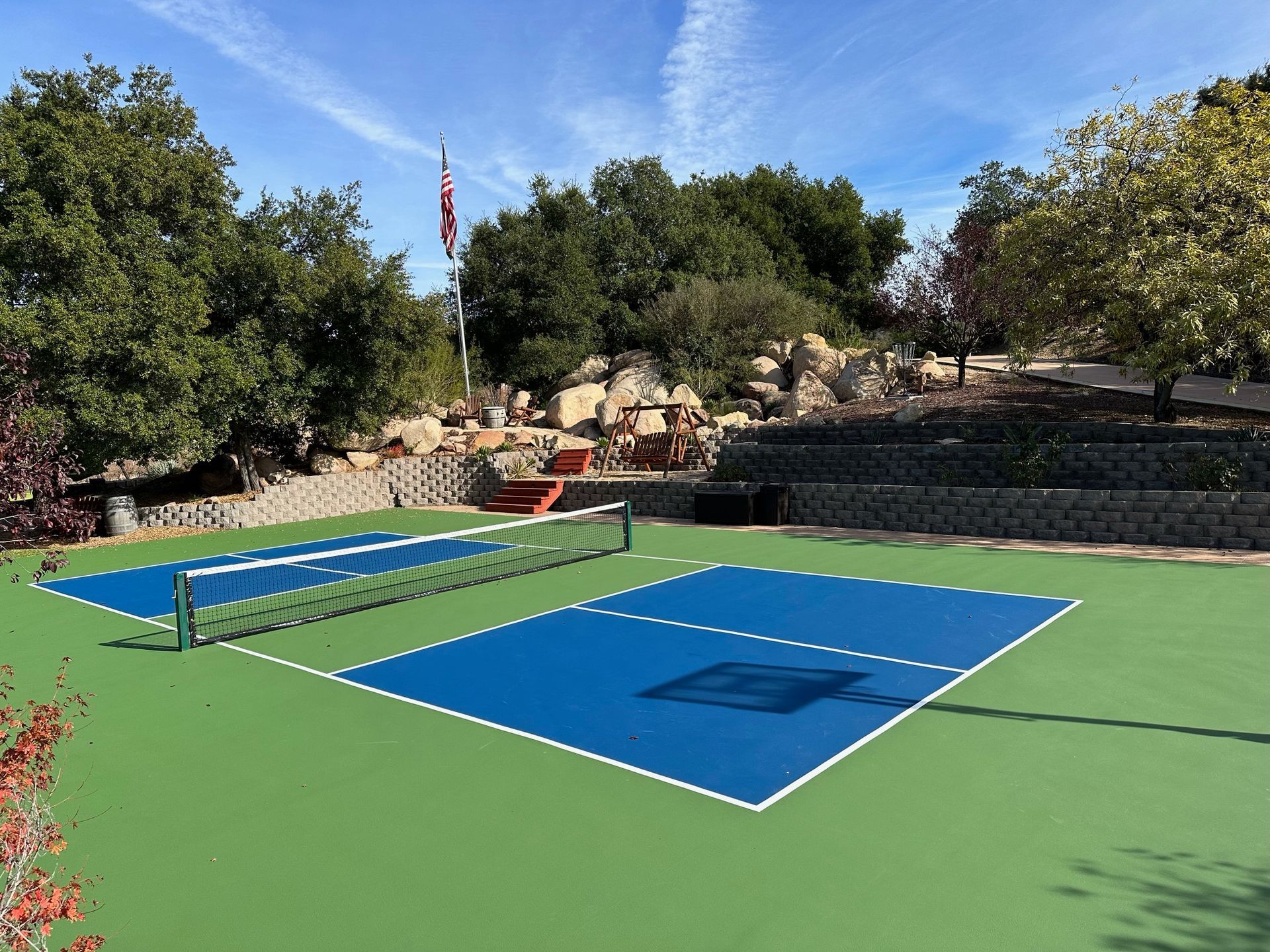 a pickleball court with a flag in the background
