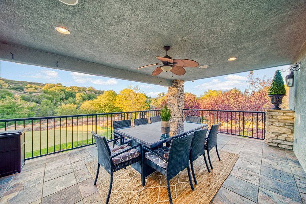a patio with a table and chairs and a ceiling fan.