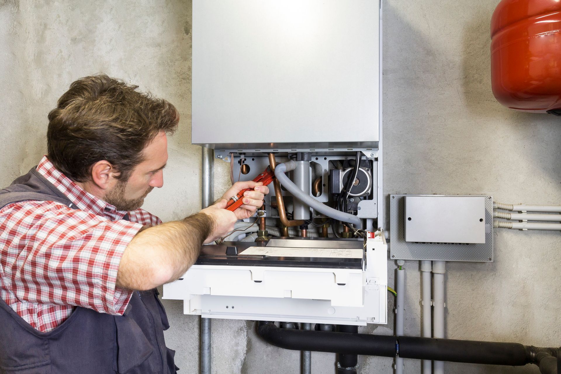 Plumber repairing a condensing boiler.