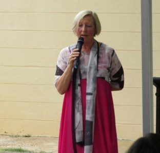 A woman in a pink dress is holding a microphone