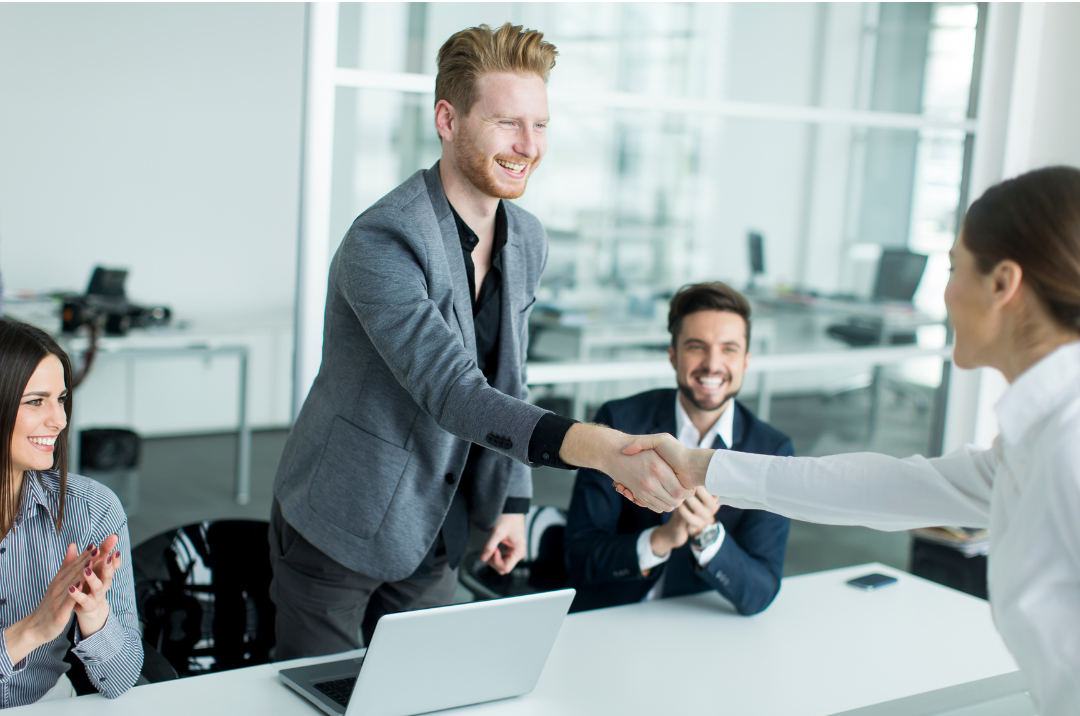 A person is typing on a laptop next to a cup of coffee.