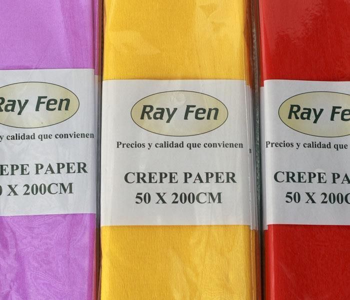 Primer plano de tres rollos de papel crepé envueltos en morado, amarillo y rojo con etiquetas de 