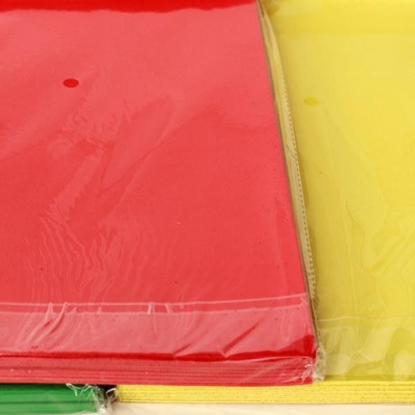 Paquetes de cartulina roja, amarilla y verde envueltos en plástico.