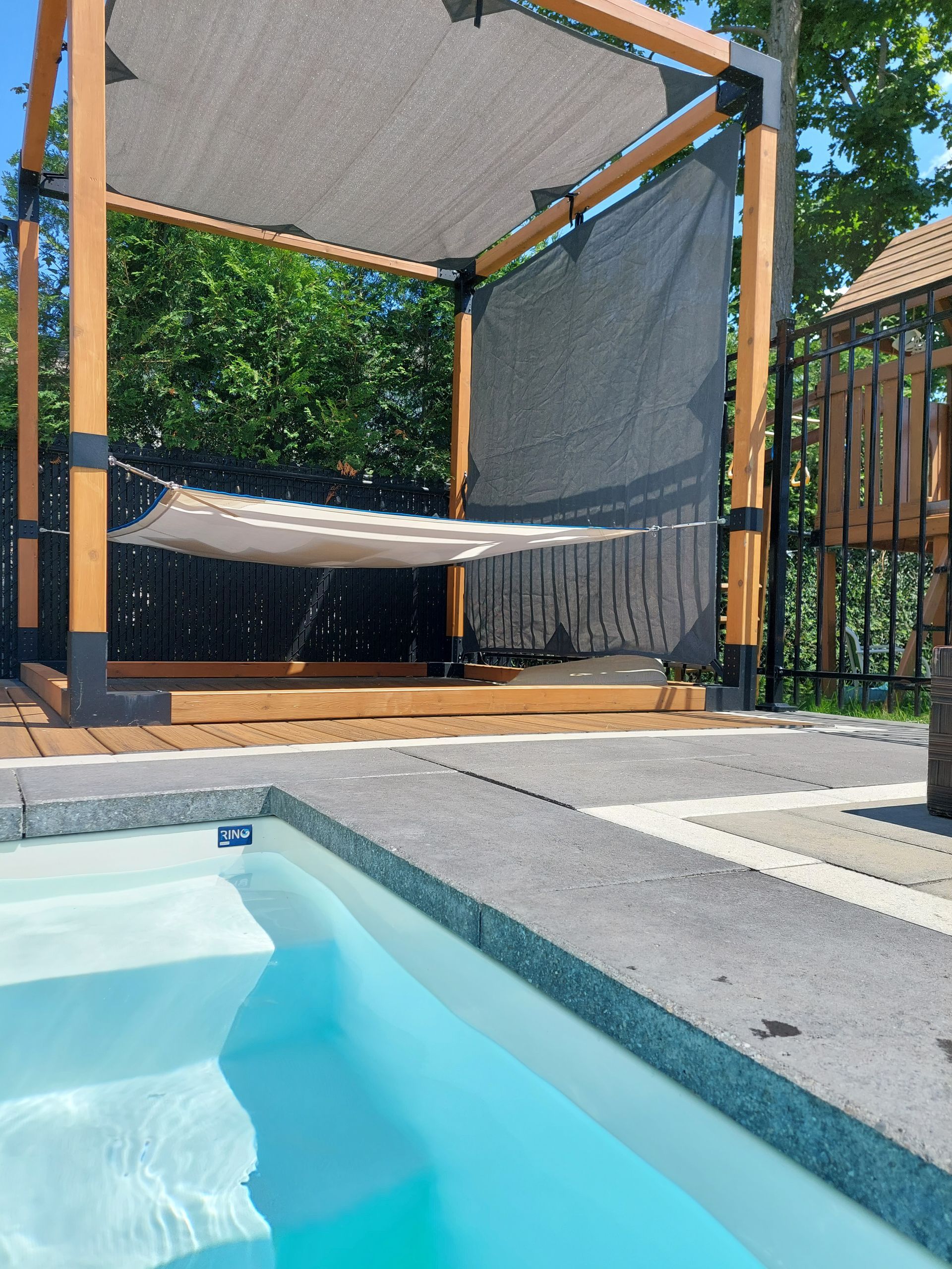 A swimming pool with a hammock hanging over it