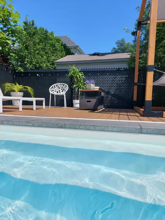 Une piscine avec des chaises et un gazebo en arrière-plan