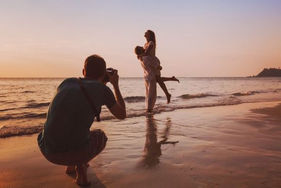 couple on the beach getting their picture taken