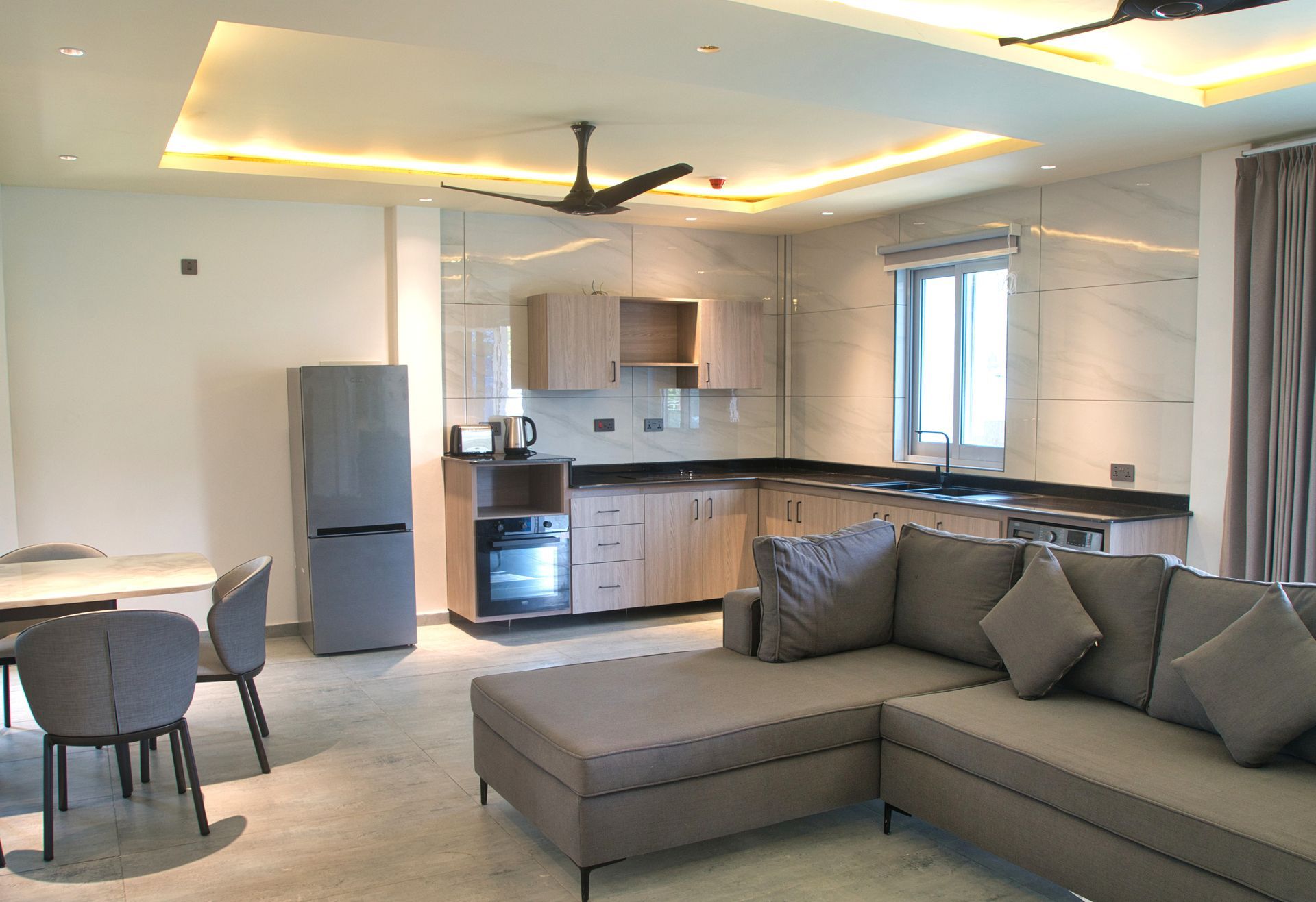 Modern apartment interior with kitchen, living area, and dining table.