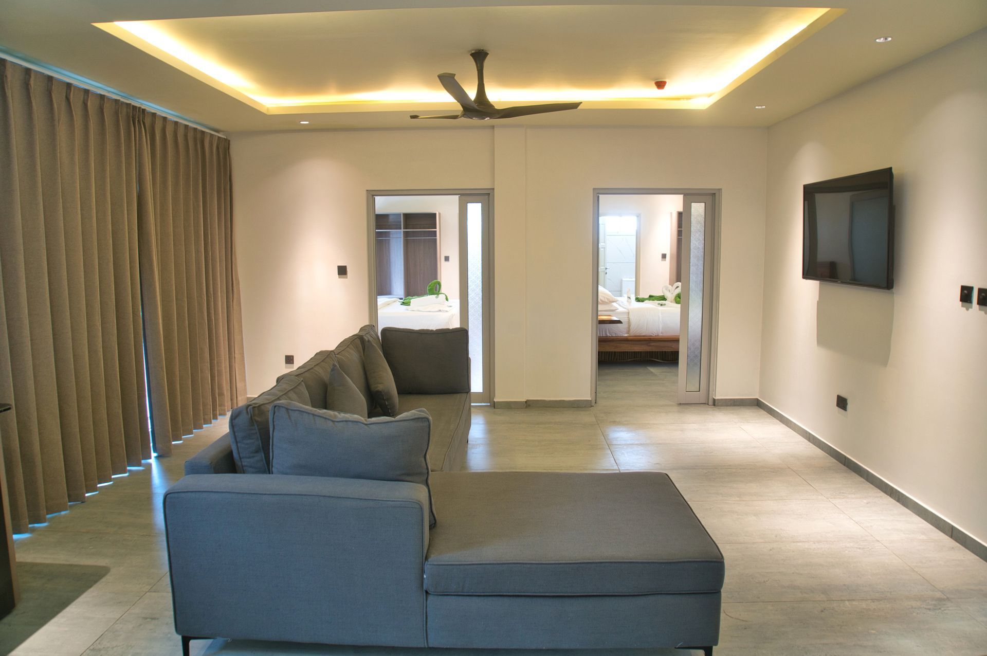 Gray sectional sofa in a modern living room with open doorways.